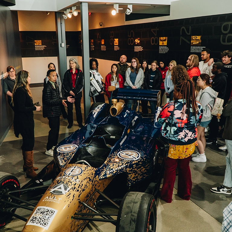 Group of people gathered around a race car.