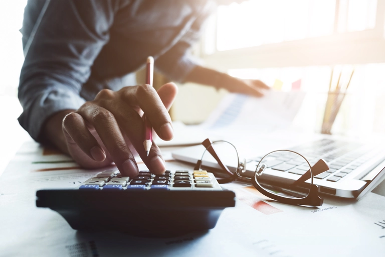 Person sitting at a desk using a calculator