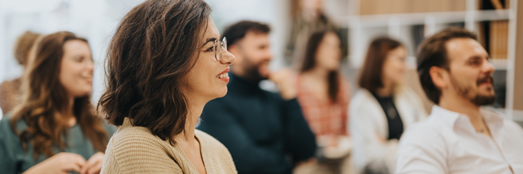 Smiling woman participating in a classroom activity with other students in classroom