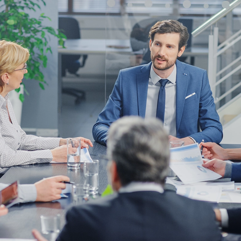 A group of business people seated around a table at a meeting.