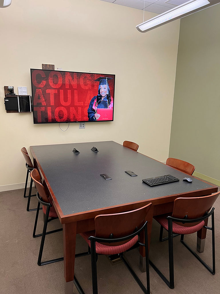 IU Southeast Library group study room with a table, chairs, and wall-mounted TV