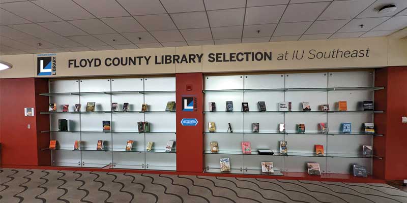 Bookshelves in IU Southeast library with the words Floyd County Library Section above