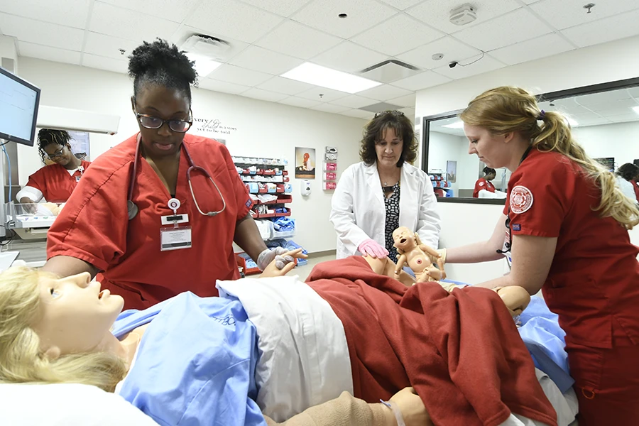 Nursing students and instructor simulating a patient giving birth