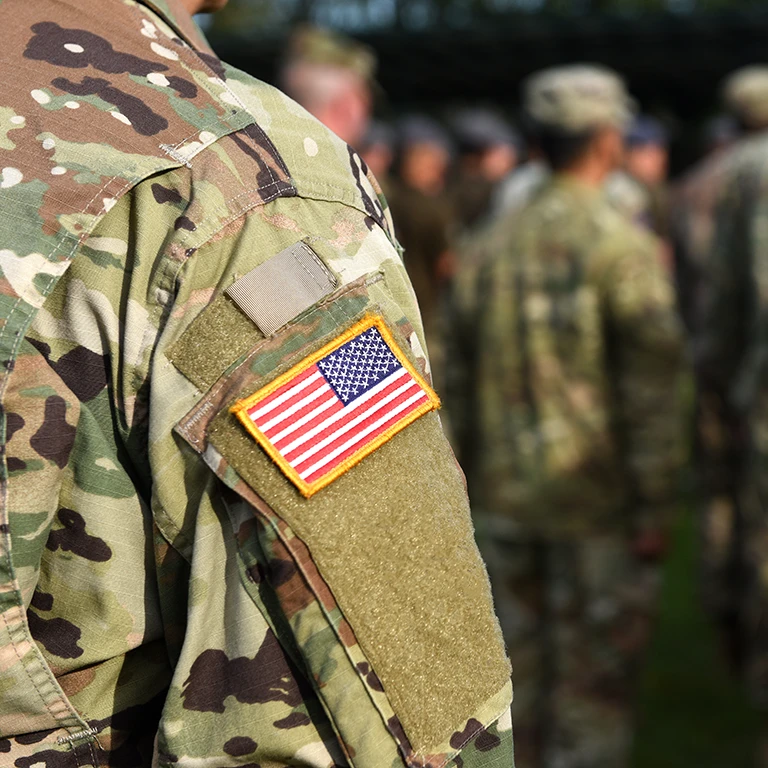 A veteran wearing fatigues with a US flag patch on his arm