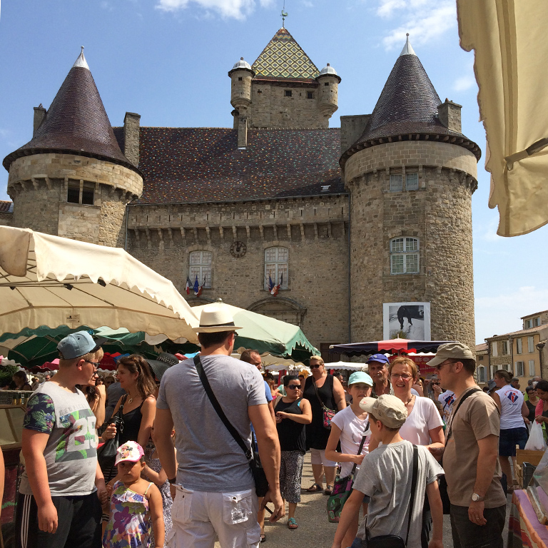 Crowded street market in front of a castle