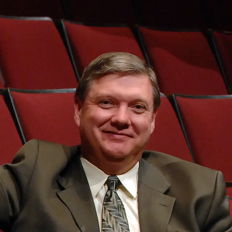 Portrait of former Ogle Center manager Kyle Ridout sitting in red theater seats