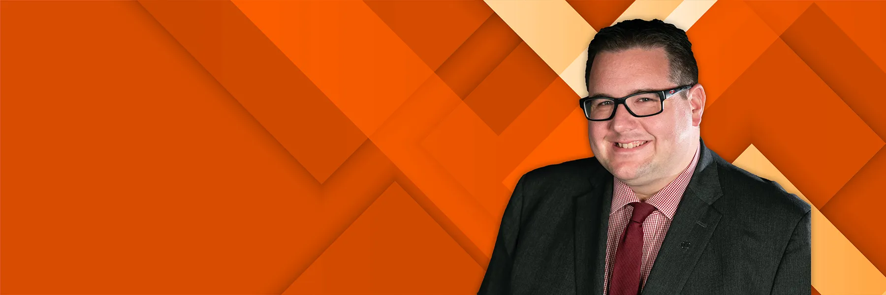 Interim Vice Chancellor of University Relations Joe Glover on an orange geometric background